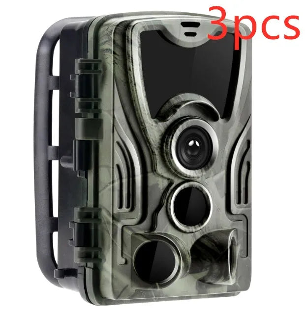 Green cellular trail game camera mounted on a tree trunk for remote deer and wildlife monitoring.