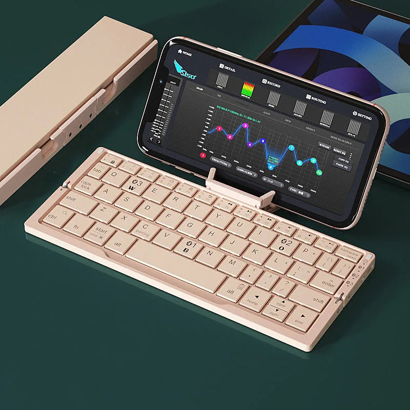 Silver folding Bluetooth keyboard open with tablet on stand, showing compact size and 60-key layout