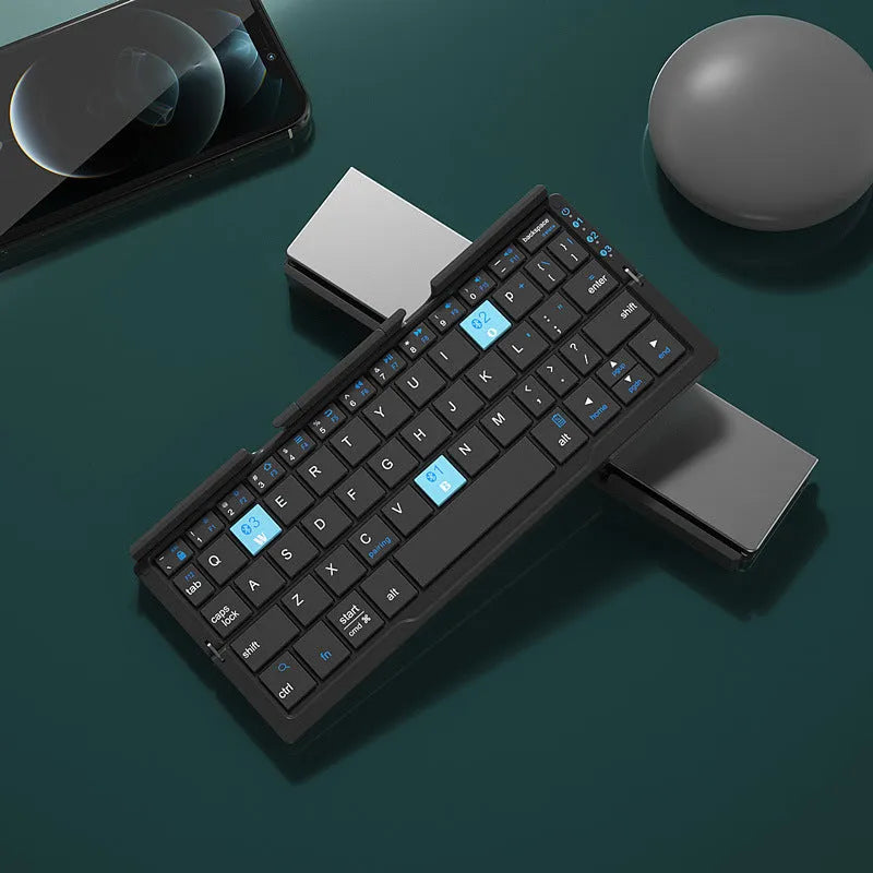 Silver folding Bluetooth keyboard open with tablet on stand, showing compact size and 60-key layout
