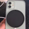 Black magnetic bracket wireless charger with Type-C port holding a mobile phone at an angle