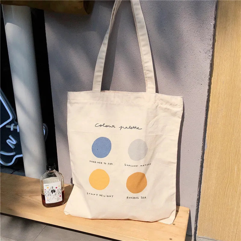 Medium geometric print canvas tote bag with soft handles, shown in light pink and orange colour options.