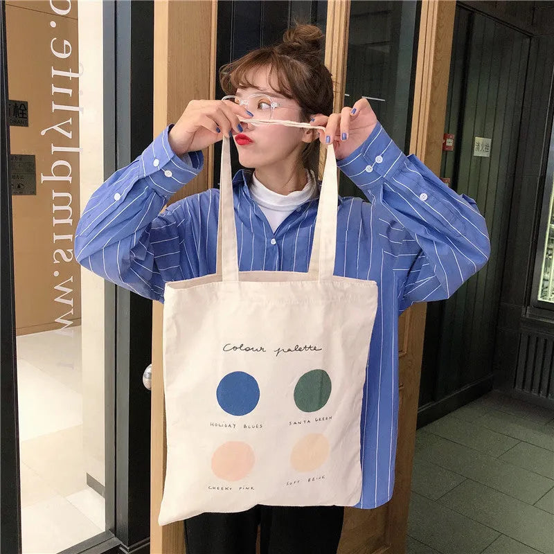 Medium geometric print canvas tote bag with soft handles, shown in light pink and orange colour options.