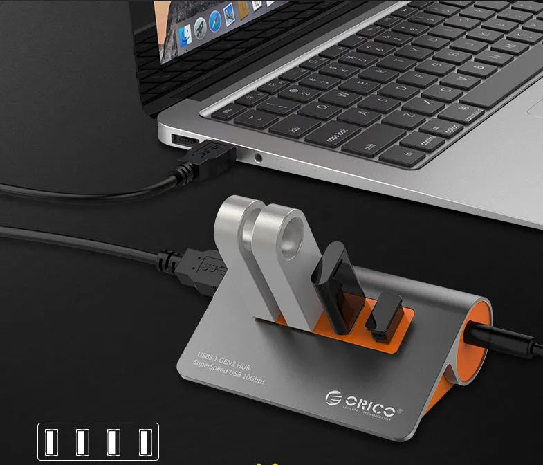 Dark grey aluminium USB hub with orange accents and separate cable showing four USB 3.1 ports