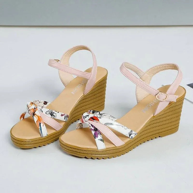 Women's pink wedge sandals with waterproof platform and buckle closure on white background