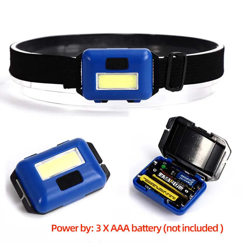 Compact black outdoor LED headlight with adjustable polyester strap on a grey background.