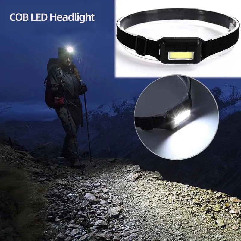 Compact black outdoor LED headlight with adjustable polyester strap on a grey background.