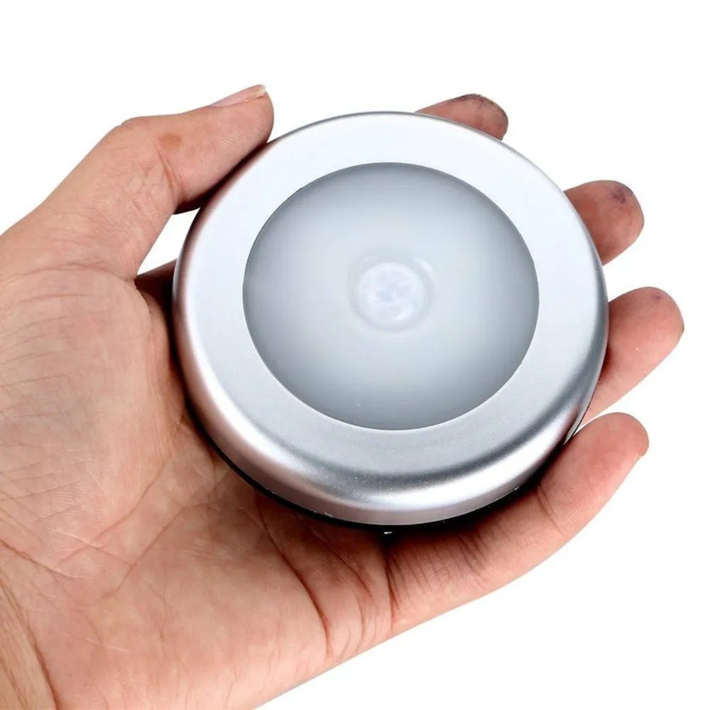 Silver square wireless motion sensor night light on a surface, showing its compact 80mm x 80mm size.