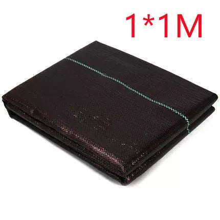 Black polyethylene woven weed proof cloth laid flat on soil, showing its texture and one of the available size options.