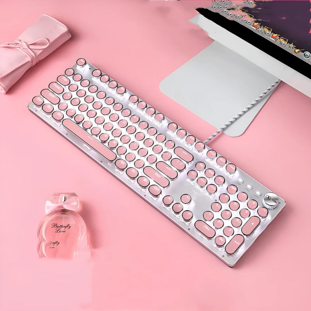 Silver and pink wired mechanical keyboard with green axis switches and a wireless mouse on a desk.
