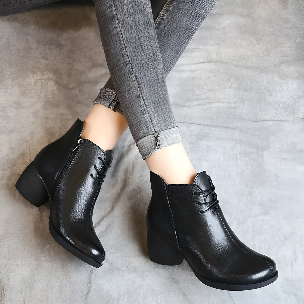 Brown women's leather Martin boots with a thick heel and round toe on a white background.