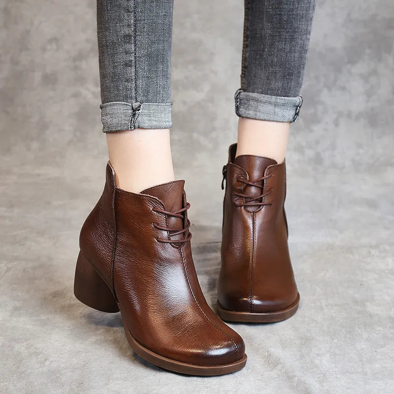Brown women's leather Martin boots with a thick heel and round toe on a white background.