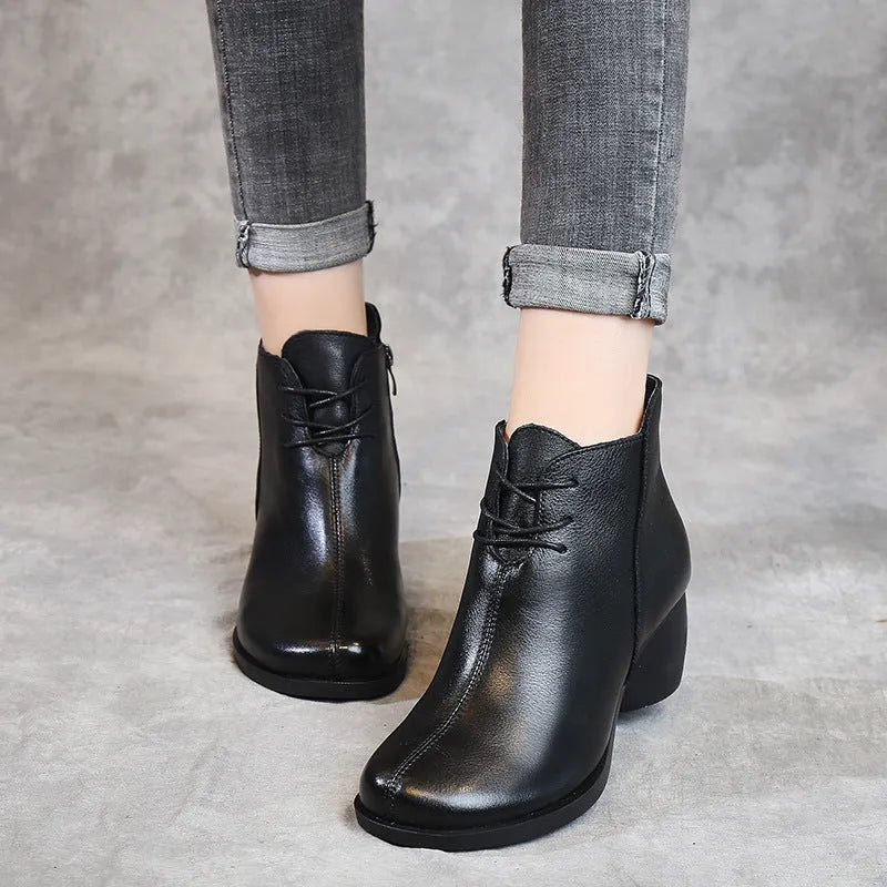 Brown women's leather Martin boots with a thick heel and round toe on a white background.