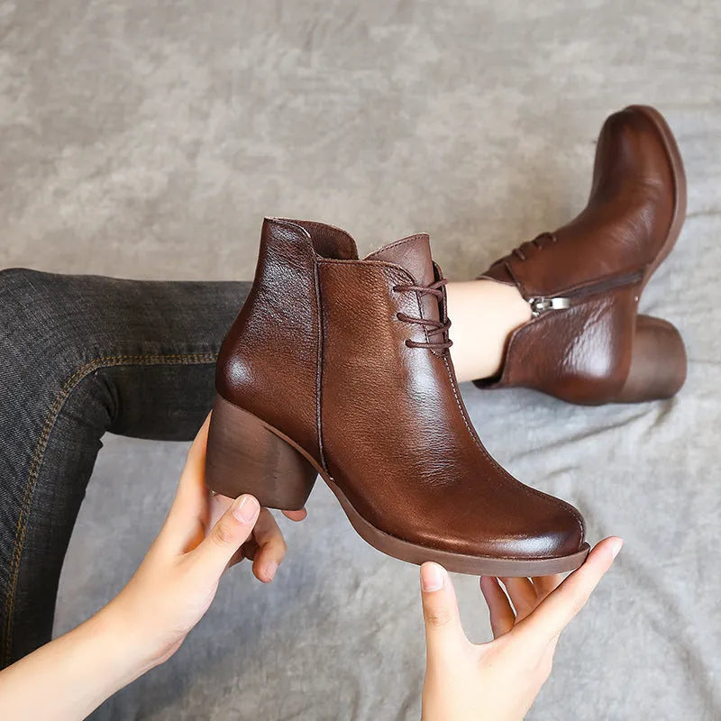 Brown women's leather Martin boots with a thick heel and round toe on a white background.