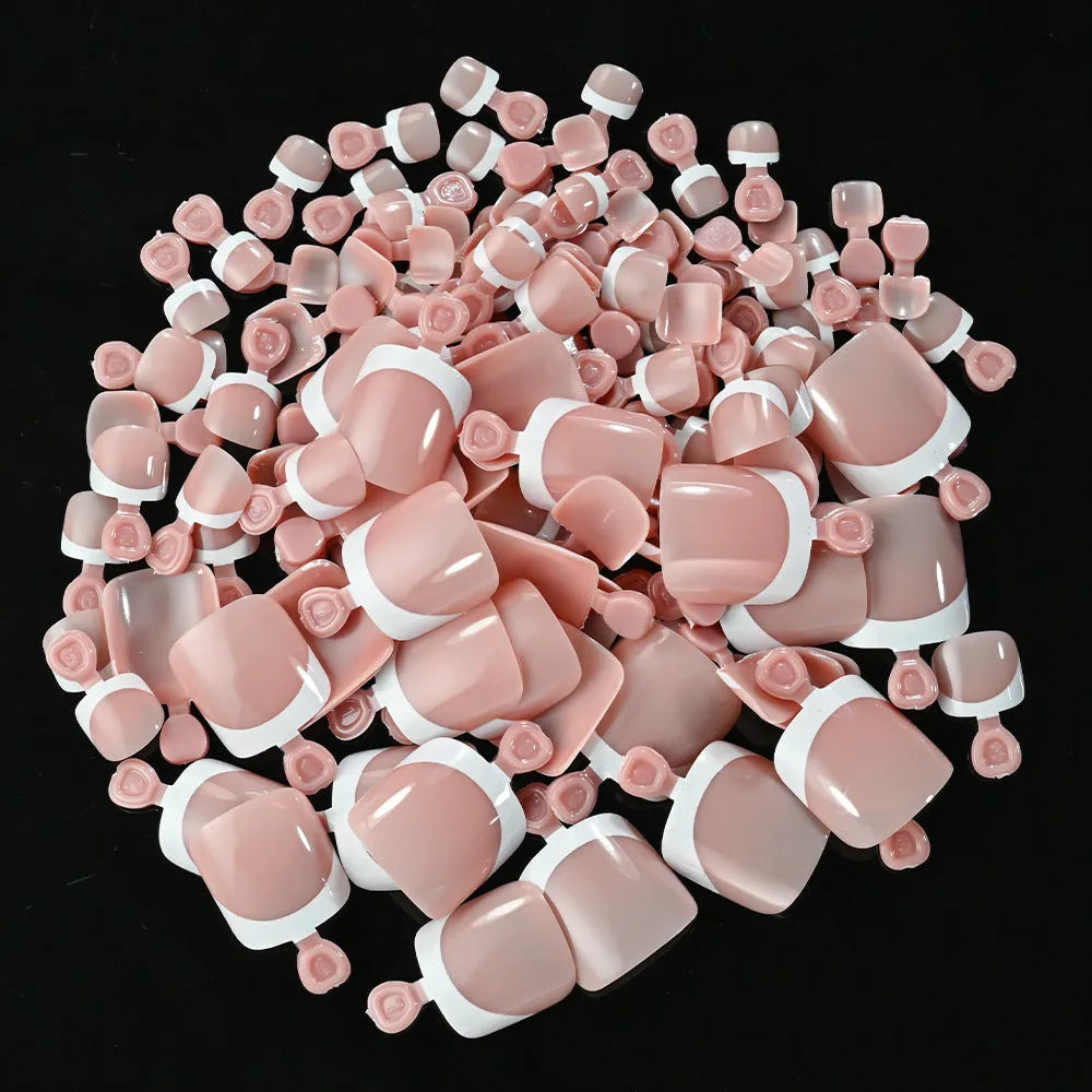 Box of 120 short square false toenails with French white tips, showing nine nude colour options from light to dark.