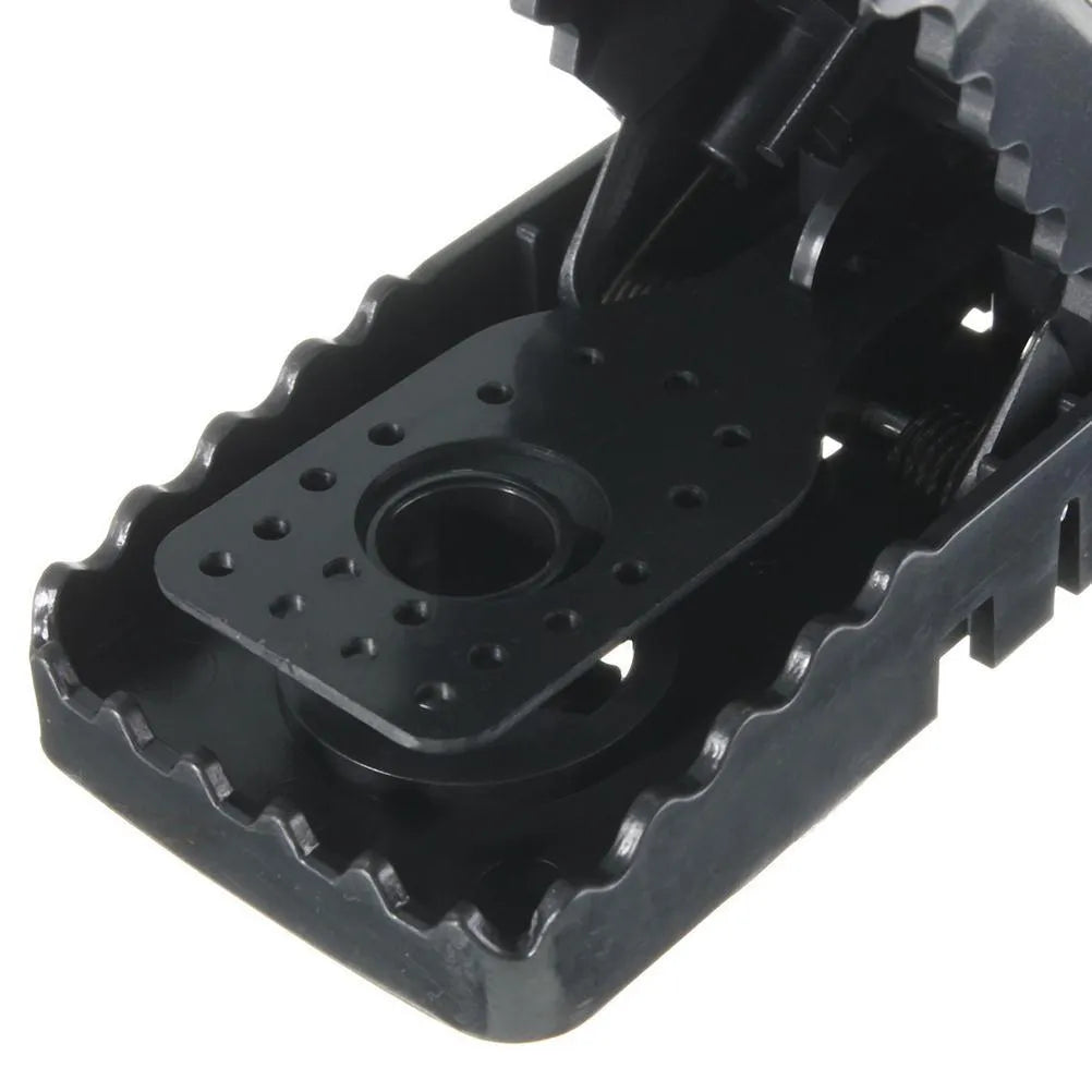 Six black plastic snap mousetraps laid out, each measuring 11 cm long.