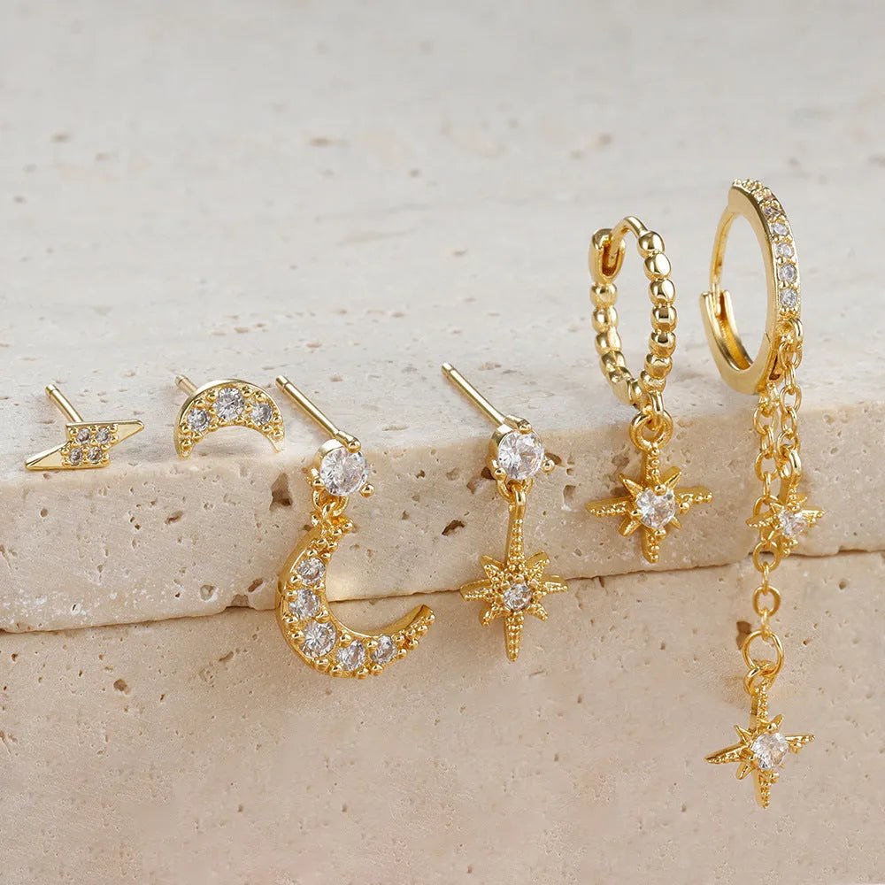 Six pairs of gold chain tassel earrings with zircon stones arranged in display