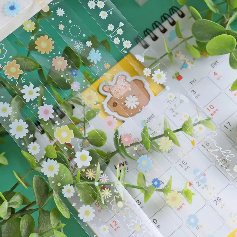 Five rolls of transparent adhesive tape with a yellow and white midsummer daisy cartoon pattern, each 1.5cm wide.