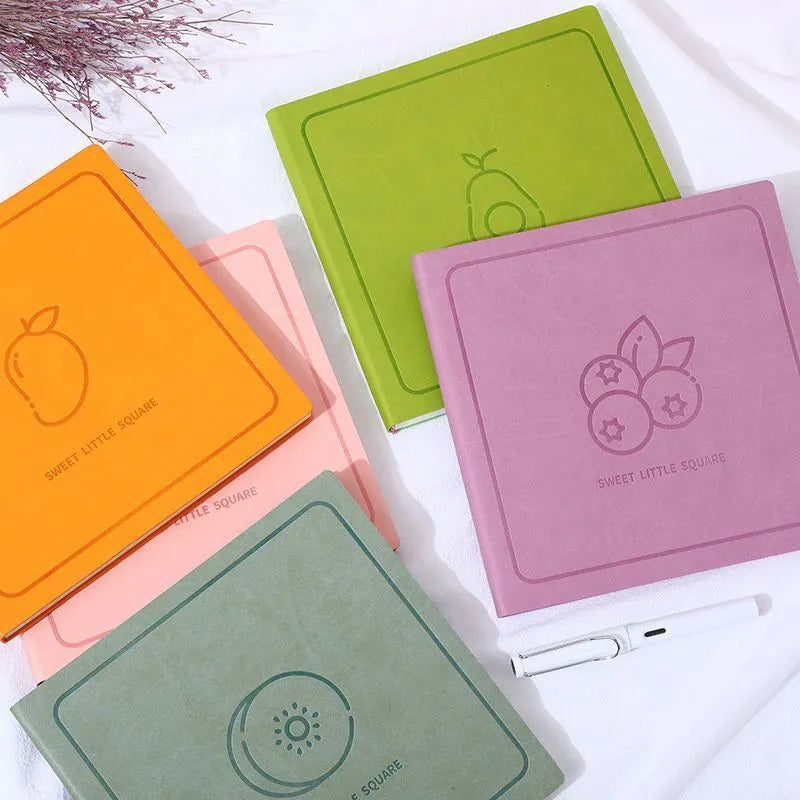 Square notebook with textured mesh leather cover showing colour options and open blank pages