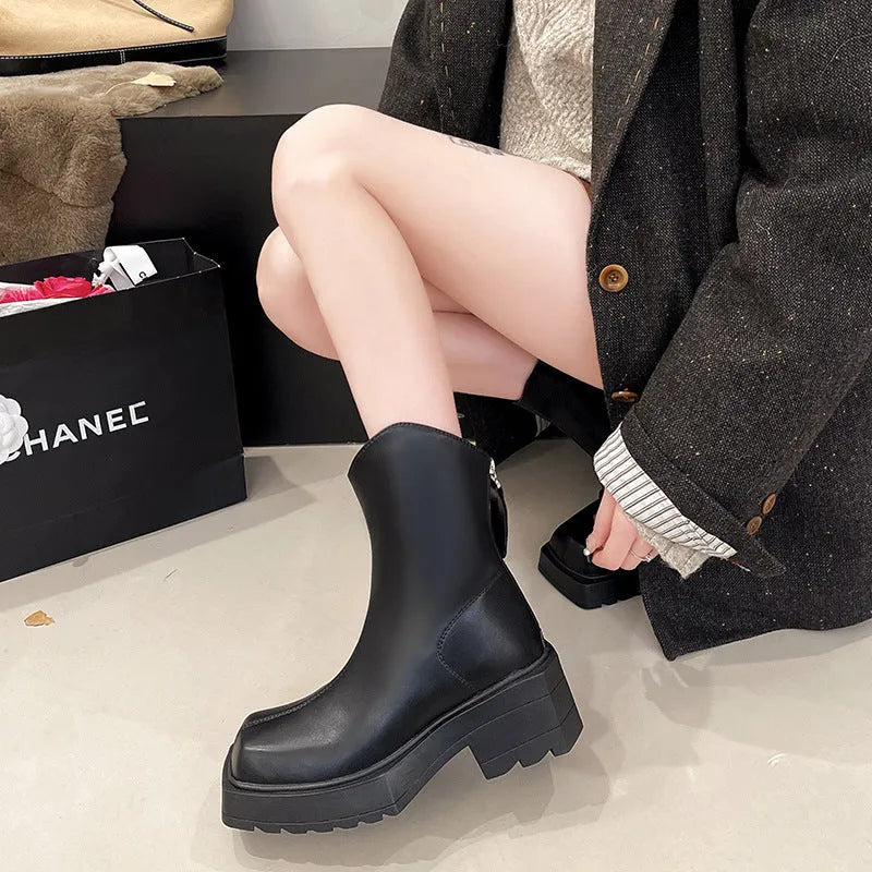 Black women's platform Martin boots with square toe, high heel, and back zip on a white background.