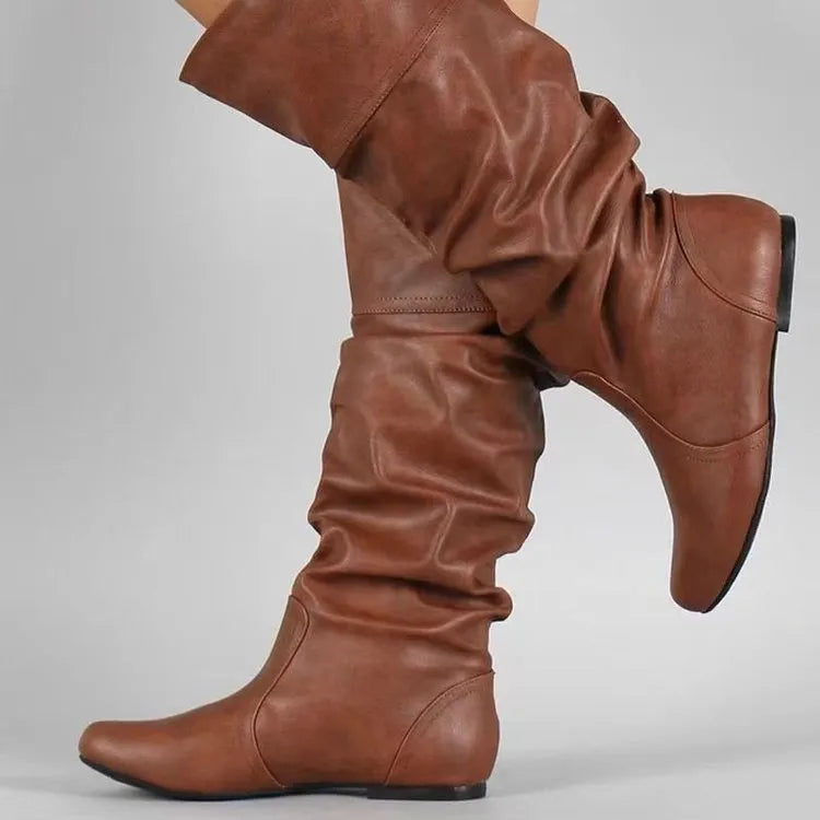 Women's black flat slip-on ankle boots with round toe and high shaft on a neutral background