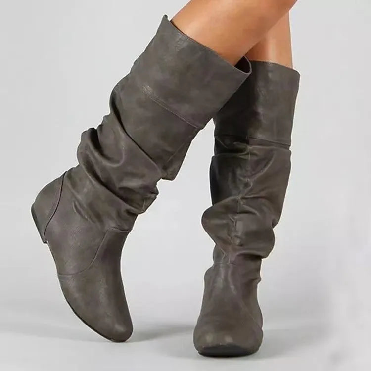 Women's black flat slip-on ankle boots with round toe and high shaft on a neutral background