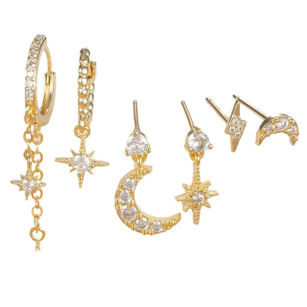 Six pairs of gold chain tassel earrings with zircon stones arranged in display