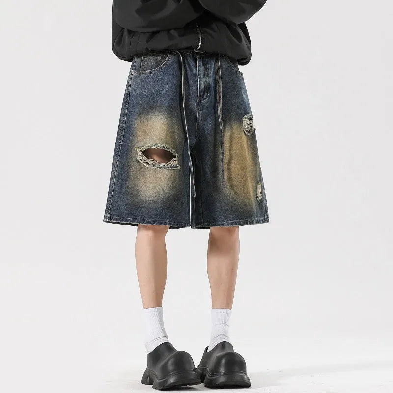 Retro blue loose-fit distressed denim jeans on a hanger, showing ripped detailing.