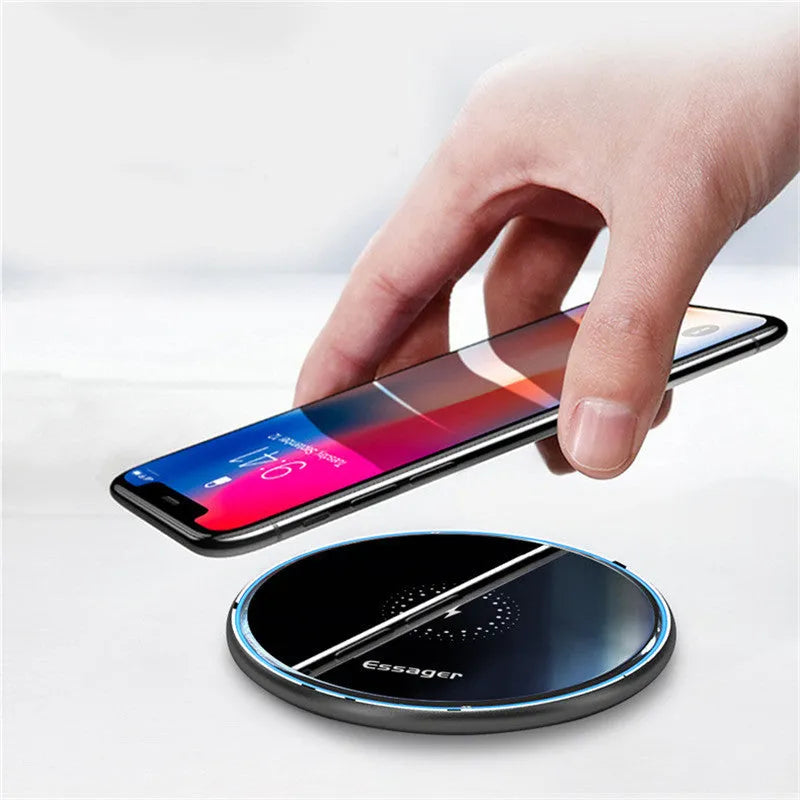 Black 15W Qi fast wireless charging pad with aluminium body and LED light, shown next to a smartphone.