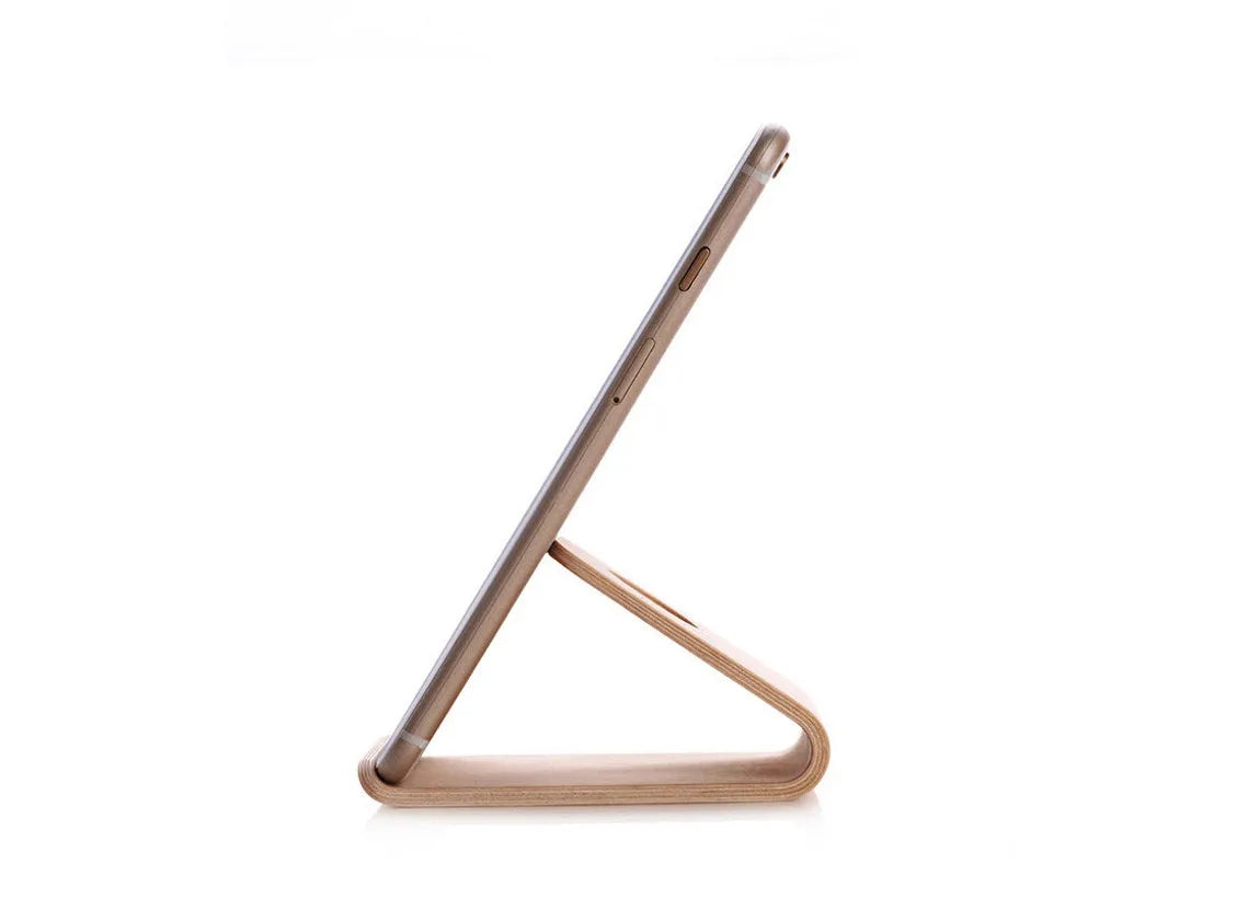 Minimalist wooden phone stand for Apple iPhone in walnut finish on a desk.