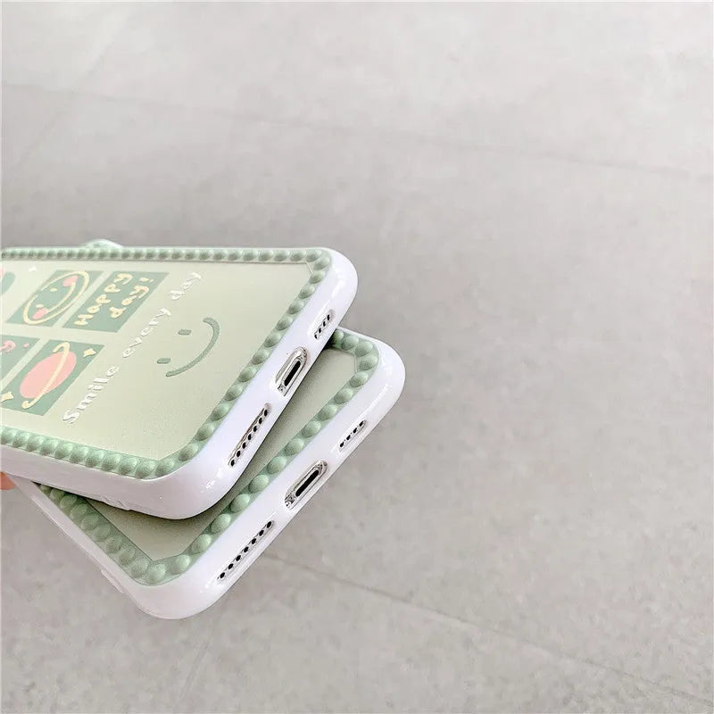 Green TPU iPhone case with a smiley face and polka dot geometric design on a table.