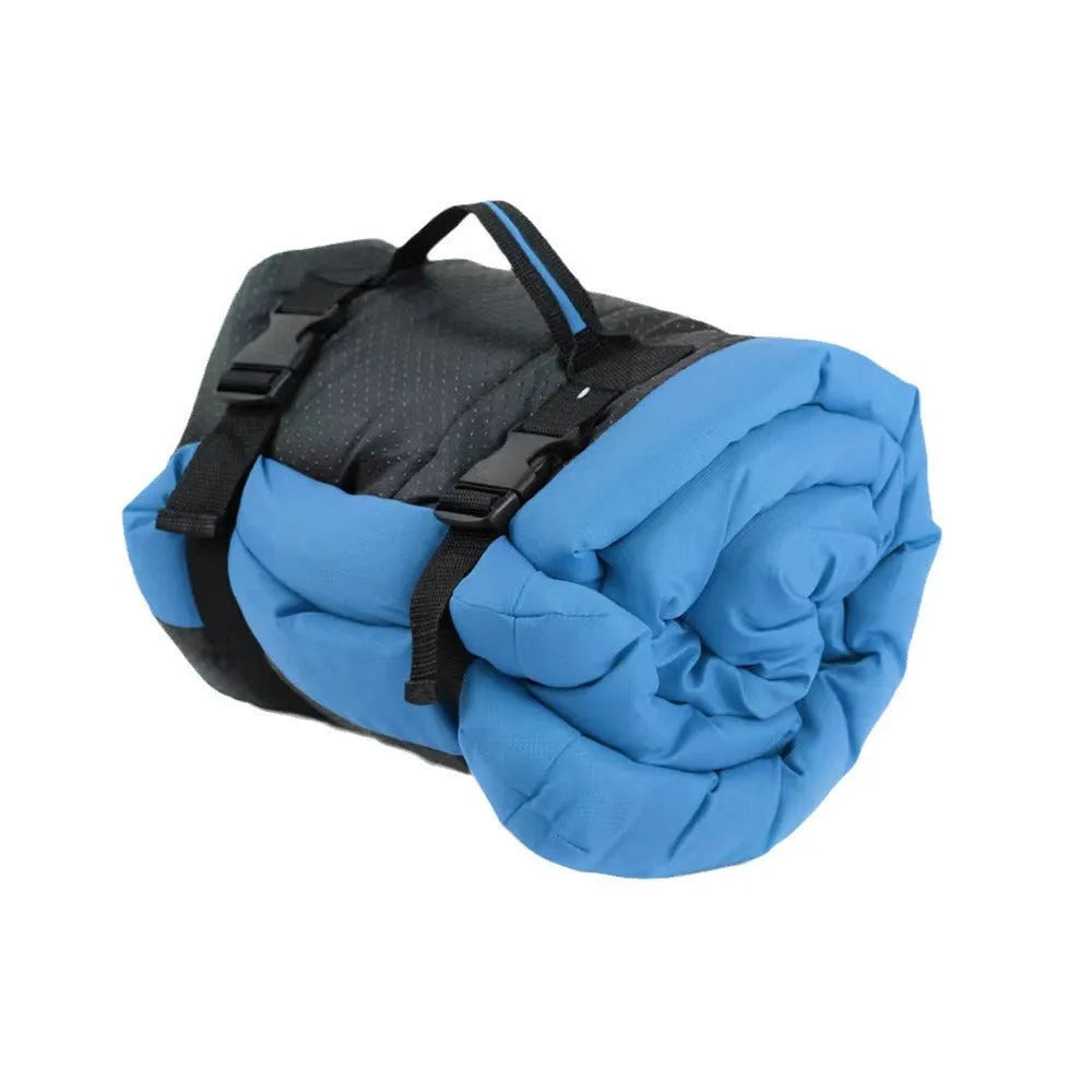 Blue foldable outdoor dog bed showing folded size next to unfolded mat on grass