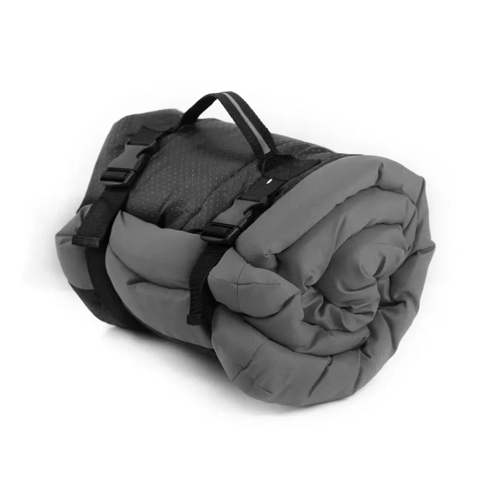 Blue foldable outdoor dog bed showing folded size next to unfolded mat on grass