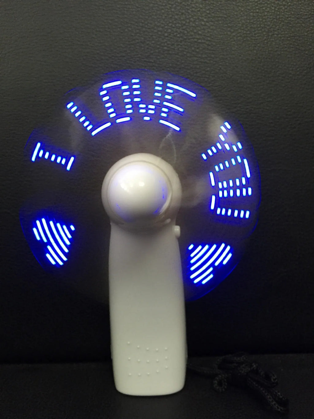 White handheld mini fan showing blue and red LED lights forming a heart and 'I love you' message.