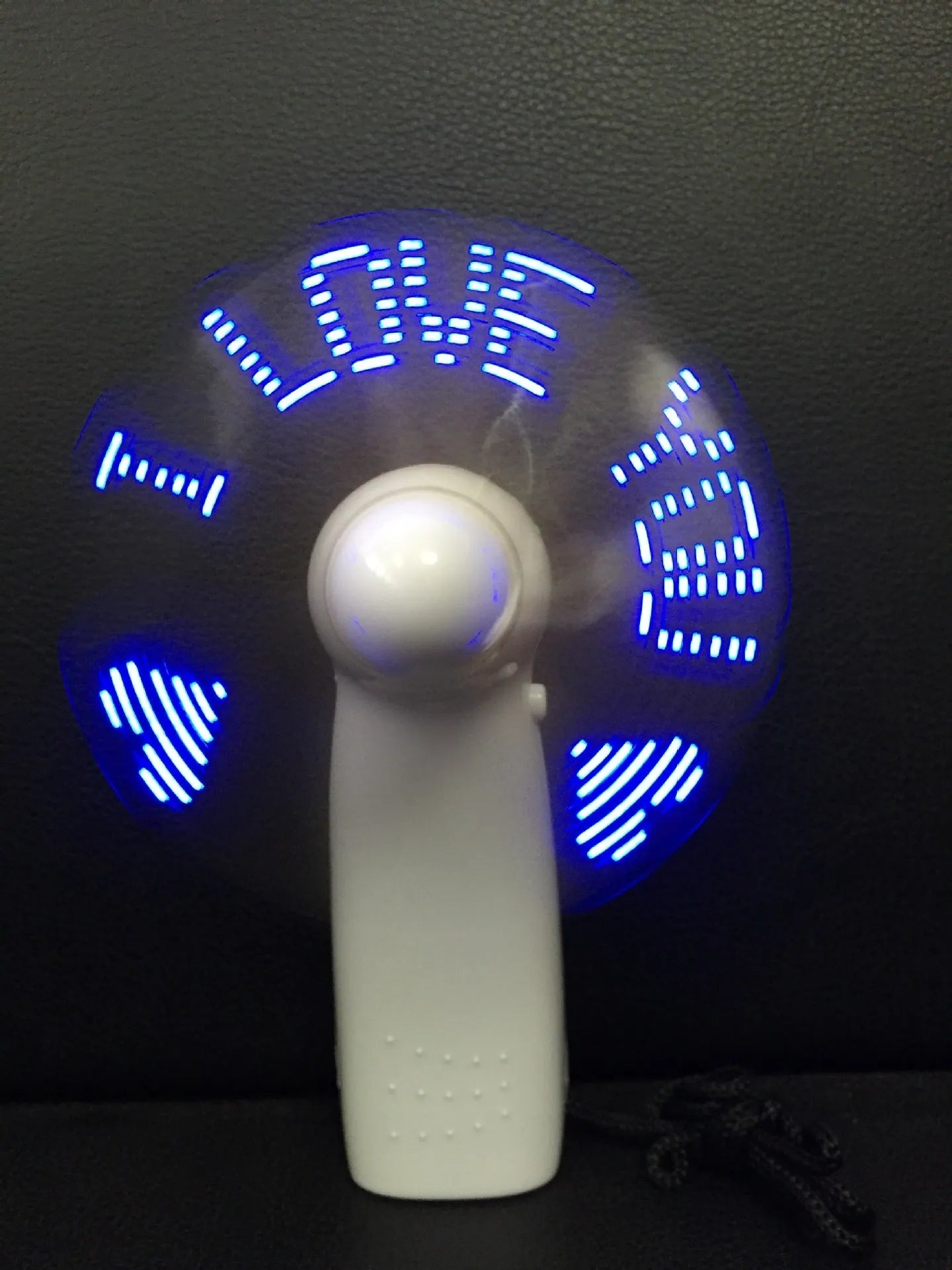 White handheld mini fan showing blue and red LED lights forming a heart and 'I love you' message.