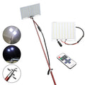 White LED fishing rod light unit mounted on top of an extended telescopic pole, with an RF remote control beside it.