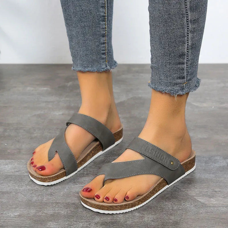 A pair of women's thick-soled flip-flops with a flat toe ring design in a solid colour.