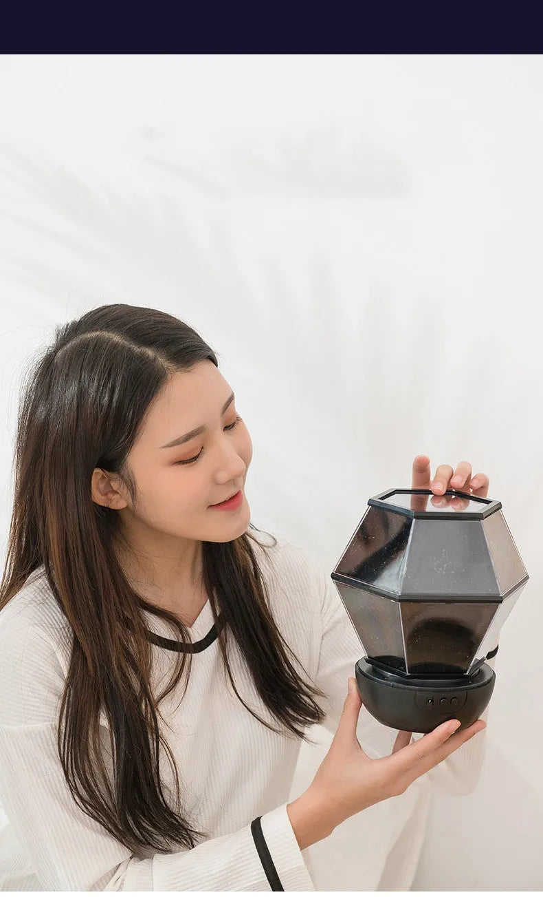 Children's rotating stars LED night light projecting star patterns on bedroom ceiling