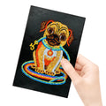 Black hardcover A5 diamond painting notebook with 50 cream pages open on craft table