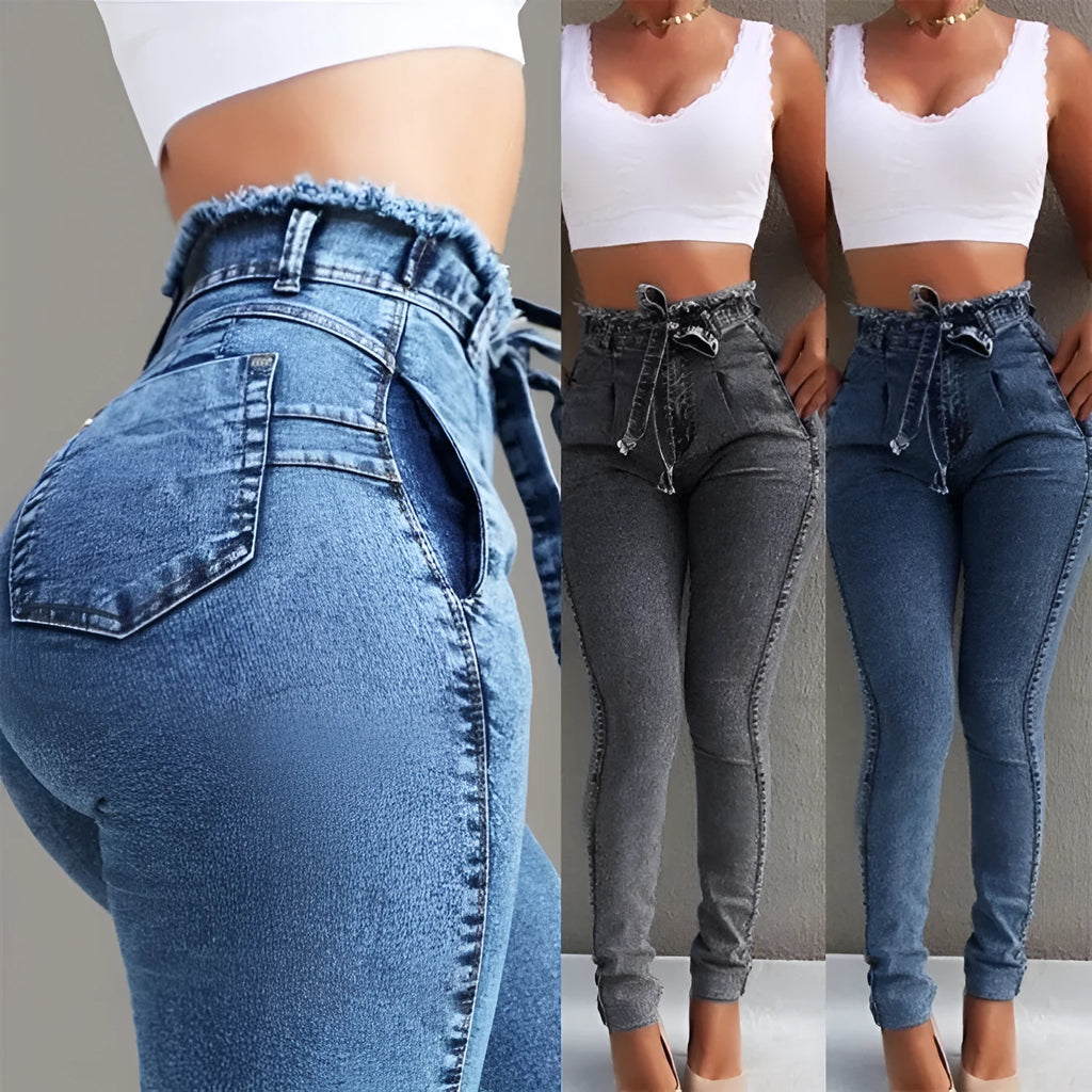 A pair of distressed grey fringed jeans made from Cowboy denim fabric on a neutral background.