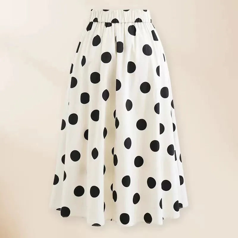 Women's black one-piece swimsuit with a white bow and round skirt on a mannequin.