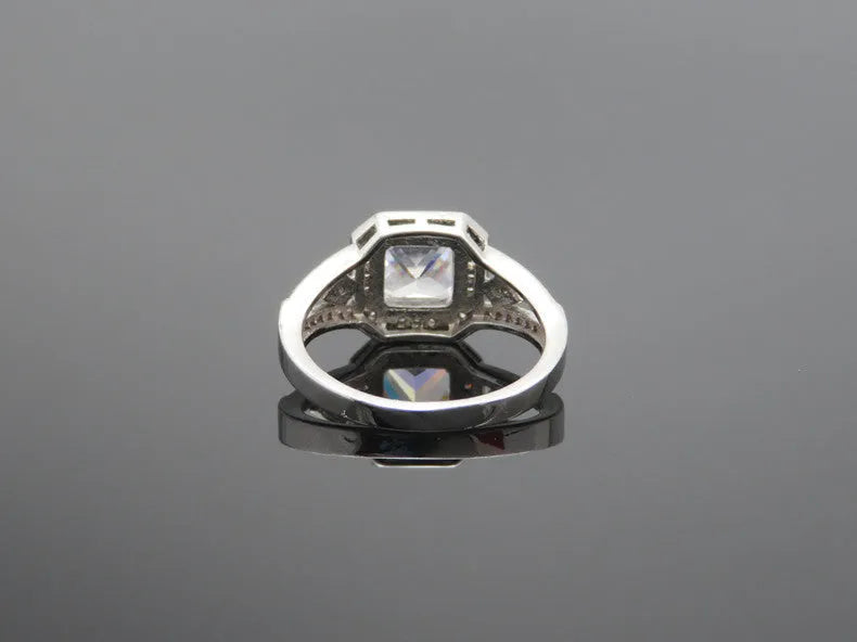 Geometric zircon ring with hollow design in platinum colour on copper, showing quadrilateral pattern and inlaid detailing