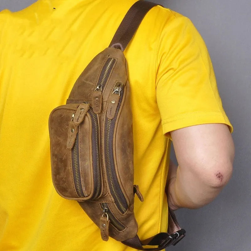 Brown cowhide leather messenger bag with a single shoulder strap, shown closed.