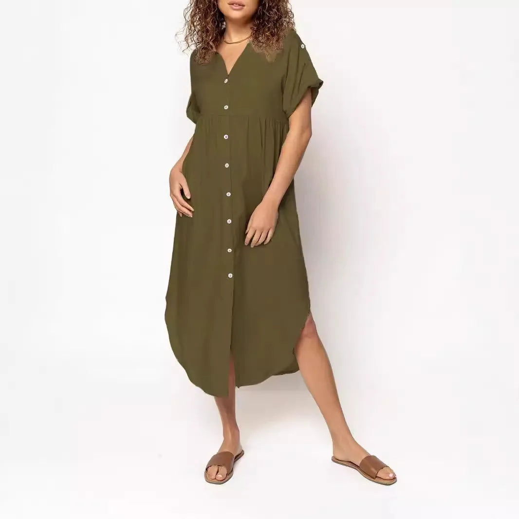 A woman wearing a loose-fitting, mid-length apricot-coloured casual dress with a button-down front.