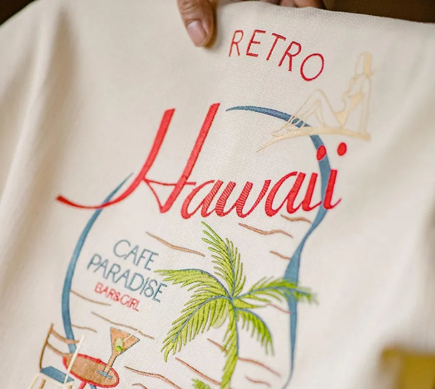 A light apricot men's shirt with a bamboo plant pattern and a relaxed Cuban collar.