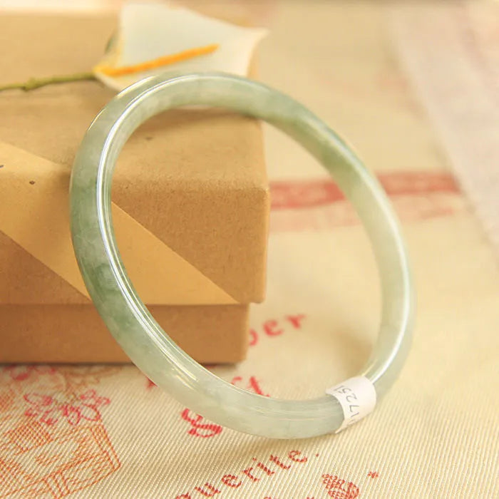 Green geometric jade waxy bracelet with 10mm diameter on a wrist.