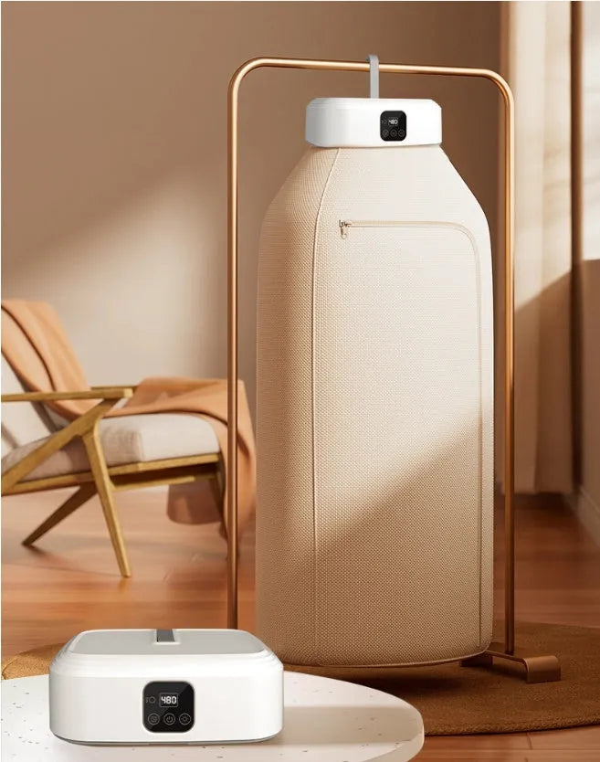 White cylindrical compact laundry dryer with remote control on countertop