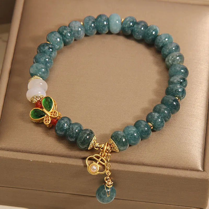 Blue water jade and white agate abacus bead crystal bracelet with rhinestone details and butterfly motif on alloy base