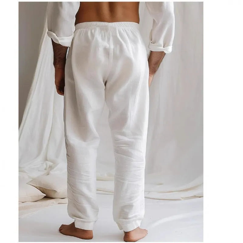 Man wearing light blue loose-fit cotton linen trousers with an elastic drawstring waist.