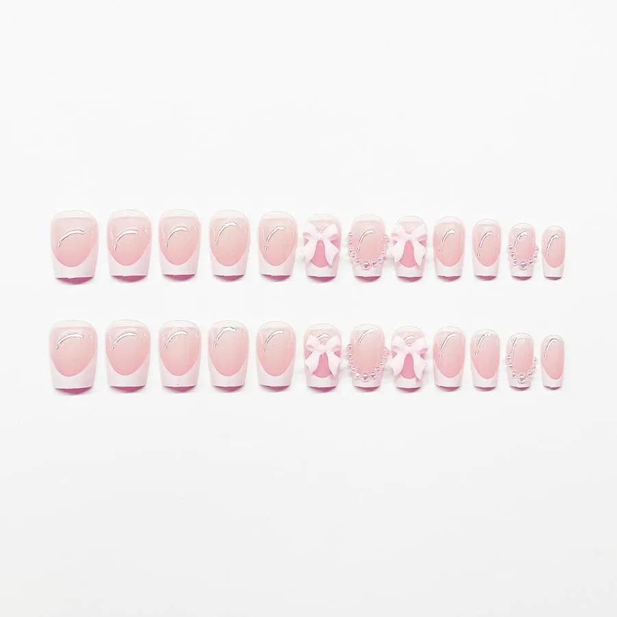 Short white French manicure press-on nails with bow designs and multiple patterns