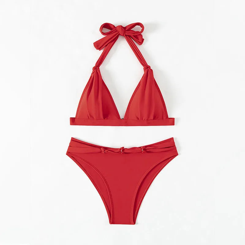 Red women's lace-up halterneck bikini set with split shorts on a mannequin.